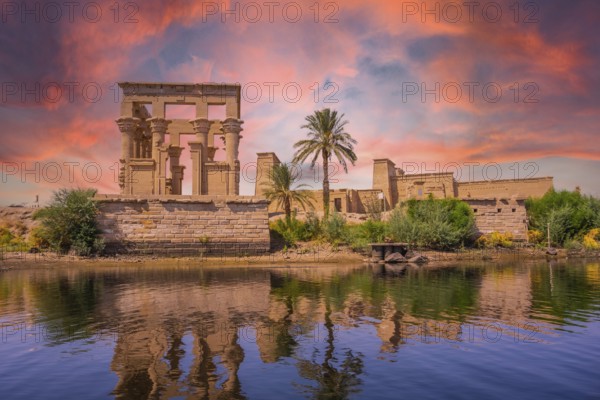 Incredible orange sunrise at the temple of Philae, a Greco-Roman construction seen from the Nile river, a temple dedicated to Isis, goddess of love. Aswan. Egyptian