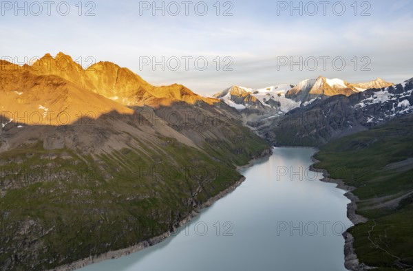 Picturesque mountain landscape at the summit Mont de la Blana at sunset, view of blue mountain lake, reservoir Lac des Dix and summit Mont Blanc de Cheilon with glacier, Hérémence, Valais, Western Alps, Switzerland, Europe