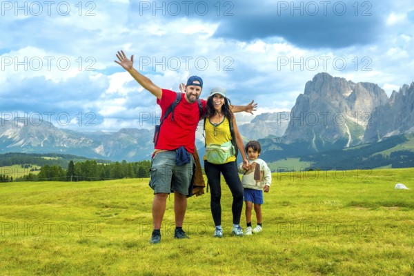 Happy family enjoying summer vacation in the italian alps, embracing the breathtaking scenery of alpe di siusi
