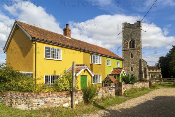 Historic cottages next to village parish church of All Saints, Rede, Suffolk, England, UK