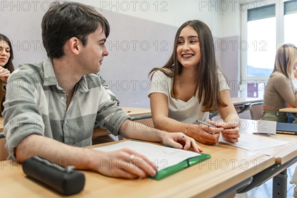 Two university students are working together on a project, sharing ideas and collaborating in a classroom setting