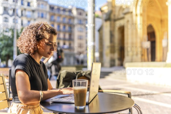 Horizontal photo with copy space of a Young arab entrepreneur working with laptop in sidewalk cafeteria