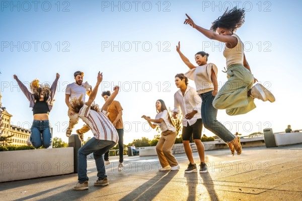 Full length photo of a group of multiracial friends jumping and dancing in the city during sunset