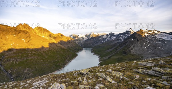 Picturesque mountain landscape at the summit Mont de la Blana at sunset, view of blue mountain lake, reservoir Lac des Dix and summit Mont Blanc de Cheilon with glacier, Hérémence, Valais, Western Alps, Switzerland, Europe