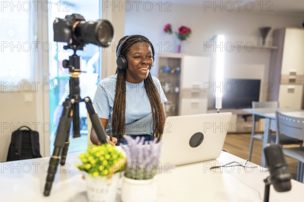 Young female content creator smiling and recording video with professional equipment in her living room