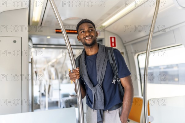 Smiling and casual african businessman travelling by metro in the city