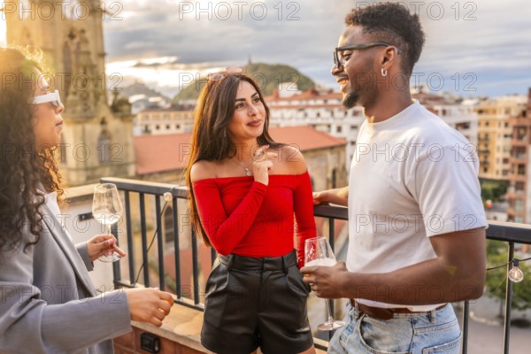 Multi-ethnic friends having an interesting conversation in a rooftop with city views during sunset