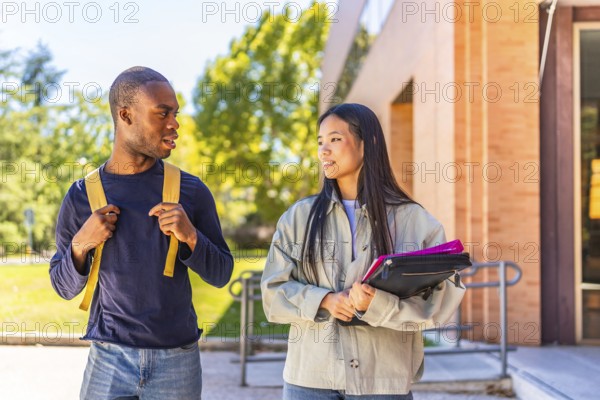 Multi-ethnic african and chinese exchange students talking walking along university campus
