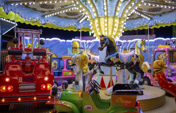 Horses, fire brigade on children's carousel, rides, neon lights, Cannstatter Wasen, funfair, spring festival, folk festival, Bad Cannstatt, Stuttgart, Baden-Württemberg, Germany, Europe