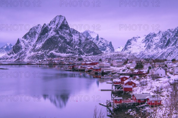 Fishermen's Village in front of snowy mountain range at the coastline in winter, Lofoten, Norway, Europe