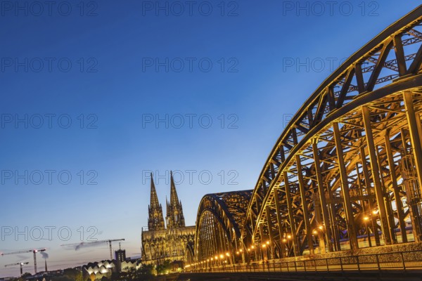 Cologne Cathedral, illuminated in the evening. Hohenzollern Bridge, railway bridge over the Rhine. City view of Cologne, North Rhine-Westphalia, Germany, Europe