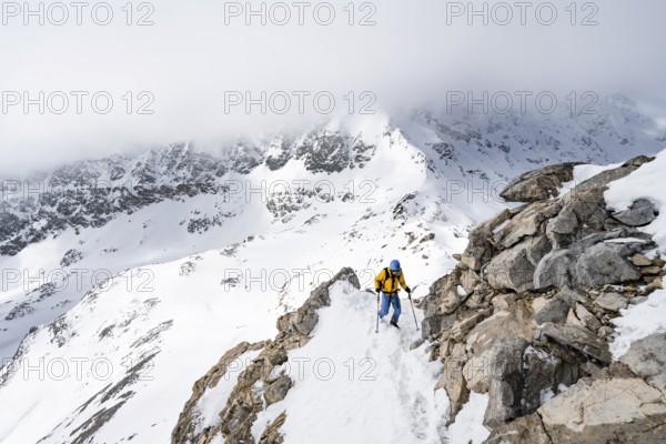 Mountaineers climbing the ridge of Piz Laviner, view of wintry mountain landscape, Grisons Haute Route, Albula Alps, Rhaetian Alps, Grisons, Eastern Switzerland, Switzerland, Europe