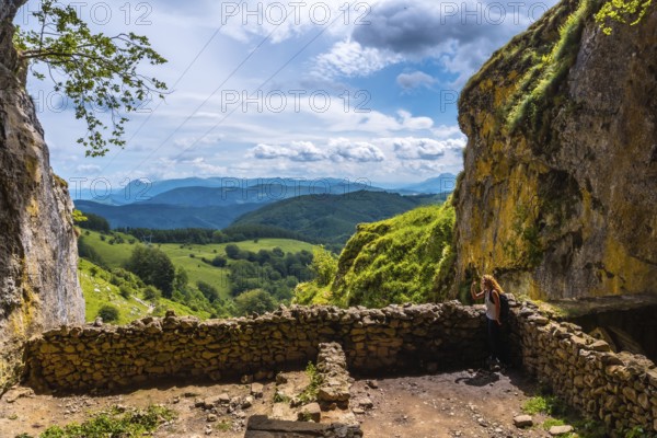 A young woman in the cave of San Adrian. Mount Aizkorri 1523 meters, the highest in Guipuzcoa. Basque Country. Ascent through San Adrian and return through the Oltza fields