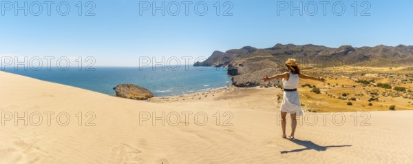 Panoramic photo of a woman enjoying views of the ocean in Cabo de Gata, Spain, Europe