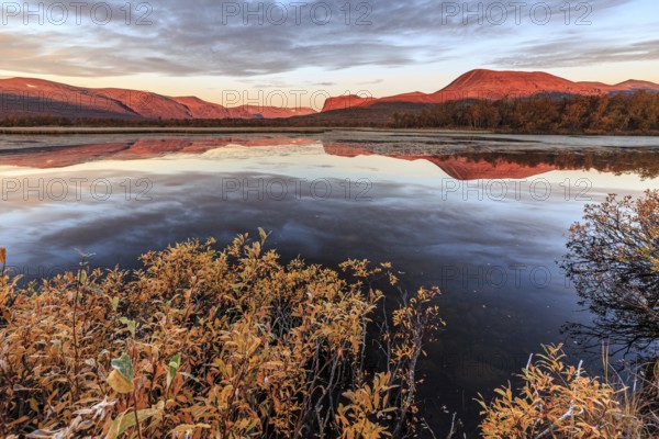 Mountains reflected in lake, autumn colours, cloudy mood, morning light, dawn, Nikkaluokta, Laponia, Lapland, Sweden, Europe