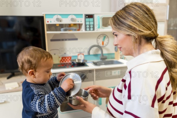 Mother and son enjoying playful moments together with a toy kitchen set in their cozy living room, fostering imagination and bonding