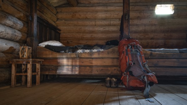 Rustic interior of a wooden hut with small beds and a rucksack and hiking boots, Olavsweg or Olavsleden, backdrop Kristin Lavranstochter film, Jørundgard Middelaldersenter, Olavsweg or Olavsleden, Sel municipality, Gudbrandsdalen, Norway, Europe