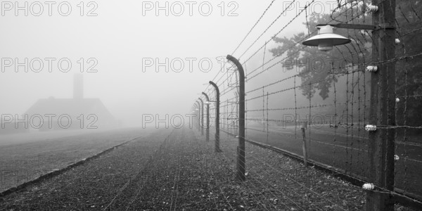 Reconstructed camp fence with crematorium in the fog at beech forest concentration camp, now a concentration camp memorial, Weimar, Thuringia, Germany, Europe