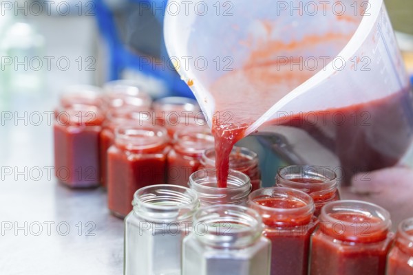 Strawberry mixture is filled into jars from a large measuring cup, jam production, Haselstaller Hof, Wildberg Gültlingen, Calw district, Black Forest, Germany, Europe
