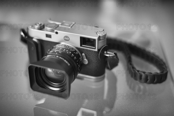 Leica M11 with Kamerakraft Grip and RocknRoll carrying strap standing on glass table, black and white, Stuttgart, Baden-Württemberg, Germany, Europe