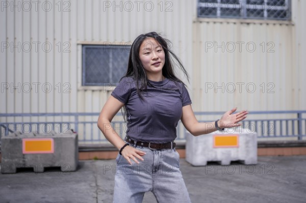 Female asian young artist dancing K-pop korean dance alone in the city