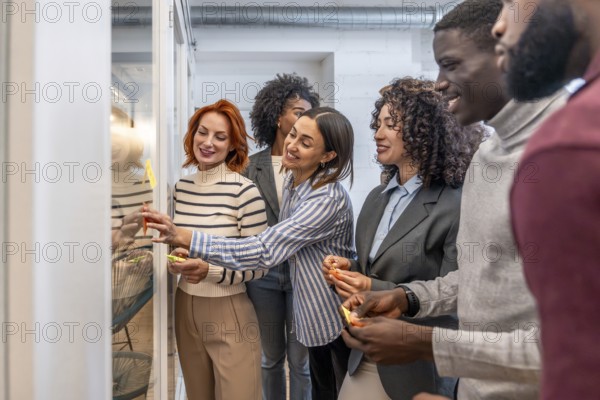Side view of a group of colleagues during a brainstorming process in a coworking space using sticky notes