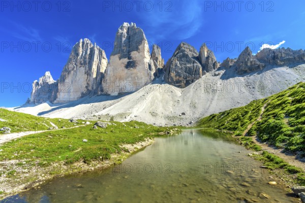 Scenic view of tre cime di lavaredo and its reflection in a mountain lake during a sunny summer day in the dolomites