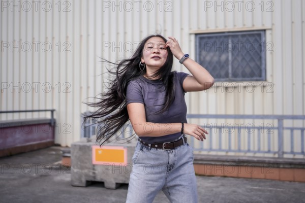 Beauty asian woman dancing modern urban k-pop dance energetically in the city