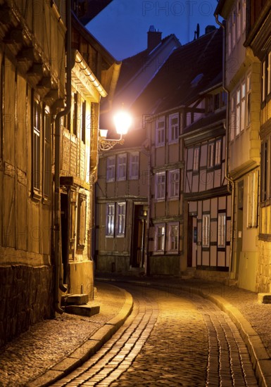 Half-timbered houses in a narrow street with cobblestones, Old Town in the evening, World Heritage City of Quedlinburg, Saxony-Anhalt, Germany, Europe