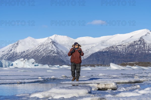 A hiker walks around the frozen lake of Jokulsarlon glacier in Iceland