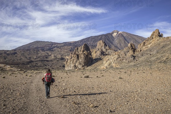 Female hiker walking towards Mount Teide, El Teide, Pico del Teide, volcano in the Teide National Park on Tenerife in the Canary Islands, Spain, Europe