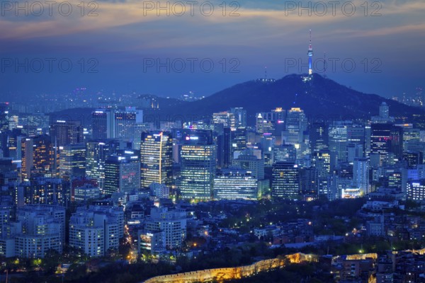Seoul downtown cityscape illuminated with lights and Namsan Seoul Tower in the evening view from Inwang mountain. Seoul, South Korea, Asia