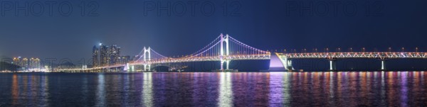 Panorama of Gwangan Bridge and skyscrapers illuminated in the night. Busan, South Korea, Asia