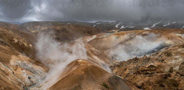 Steaming streams between colourful rhyolite mountains with snowfields, Hveradalir geothermal area, Kerlingarfjöll, Icelandic highlands, Iceland, Europe