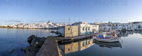 Panorama, view of the town of Naoussa and blue sea, harbour with fishing boats and reflection, white Cycladic houses and church of Agios Faneromeni, Paros, Cyclades, Greece, Europe