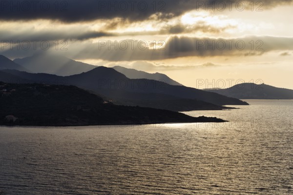 Coastline backlit, sun rays through clouds, L'Île-Rousse, Ile Rousse, Haute-Corse, Balagne, North Coast, Corsica, France, Europe