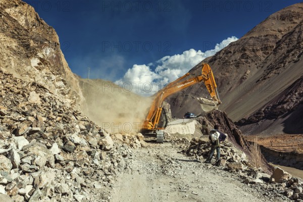 LADAKH, INDIA, SEPTEMBER 10, 2011: Excavator cleaning road after landslide in Himalayas. Ladakh, Jammu and Kashmir, India, Asia