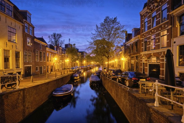 Typical Netherlands city view, canal with boats and houses illuminated in the evening. Haarlem, Netherlands