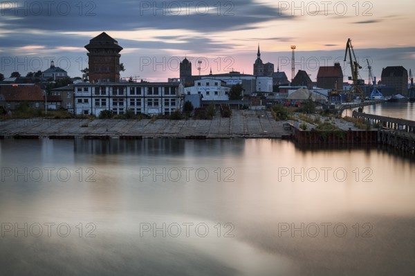 Harbour buildings, construction cranes and church towers, skyline at dusk, long exposure, Stralsund harbour, Germany, Europe