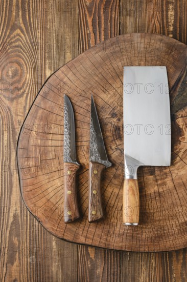 Top view of cleaver and knives on wooden stump