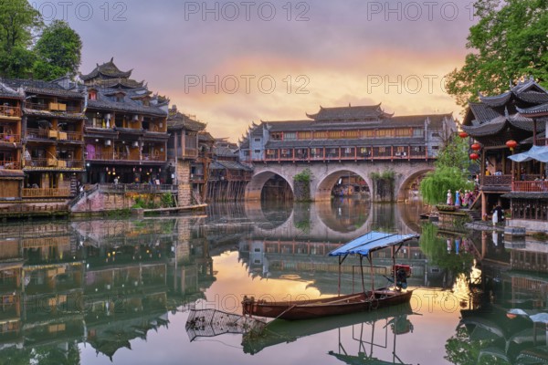 Chinese tourist attraction destination, Feng Huang Ancient Town (Phoenix Ancient Town) on Tuo Jiang River illuminated at night. Hunan Province, China, Asia