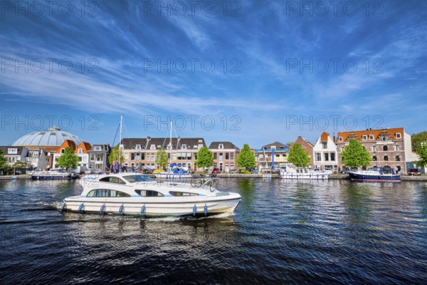 HAARLEM, NETHERLANDS, MAY 6, 2017: Boats and houses on Spaarne river with blue sky. Haarlem, Netherlands