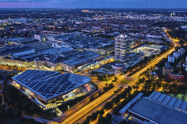 MUNICH, GERMANY, JULY 08, 2018: Aerial view of BMW Museum and BWM Welt and factory and Munich from Olympic Tower illuminated at night. BMW is a famous German luxury car automaker