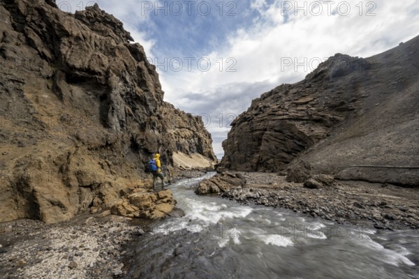 Hikers by the river, Drekagil, gorge in the crater rim of Askja volcano, Dyngjufjöll mountain range, Icelandic highlands, Vatnajökull National Park, Iceland, Europe