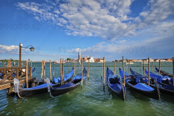Gondolas and in lagoon of Venice by Saint Mark (San Marco) square with San Giorgio di Maggiore church in background in Venice, Italy, Europe