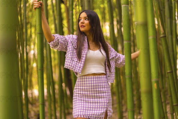 Young caucasian girl with a pink skirt in a bamboo forest. Enjoying the city on summer holidays in a tropical climate, lifestyle of a lost girl in the forest