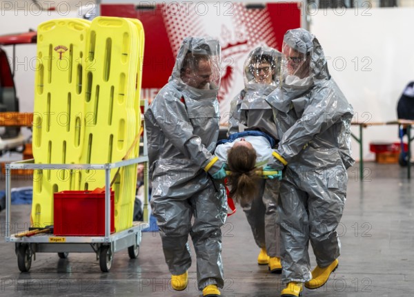 Decontamination of injured persons after an assumed accident involving hazardous substances, fire brigade and aid organisations practise setting up and operating a decontamination station, injured persons are sighted and then washed in a special shower tent to remove possible hazardous substances and chemicals in order to avoid further injuries, the emergency services wear special, ventilated protective suits, large-scale exercise by the Essen fire brigade