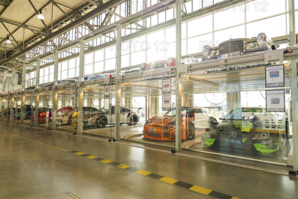 Cars in a two-storey glass garage with natural daylight and minimalist design, Motorworld Böblingen, Germany, Europe