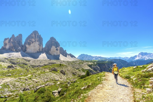 Tourist walking on a mountain path near tre cime di lavaredo, a symbol of the dolomites, a unesco world heritage site