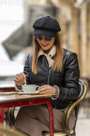 Tourist savoring a cappuccino at an outdoor cafe in bordeaux, france, enjoying the charming atmosphere and vibrant street life